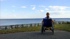 Rollstuhlfahrerin am Meer