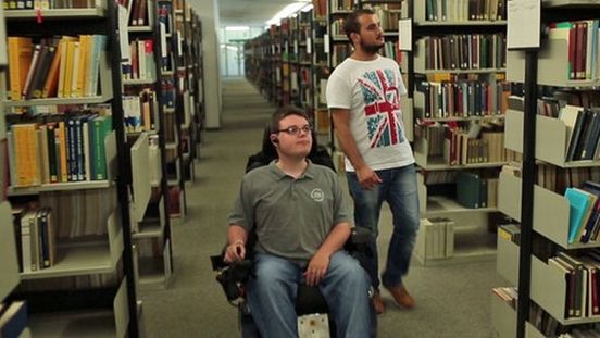 Constantin Grosch mit Assistenten in einer Bibliothek